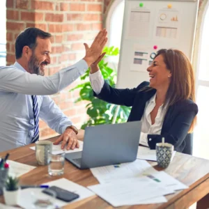 Two colleagues celebrating together in an office